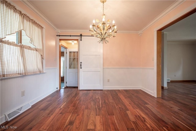 573 Grandview Ave, East Palestine, OH 44413 - unfurnished dining area featuring a barn door, a chandelier, a wainscoted wall, wood finished floors, and crown molding