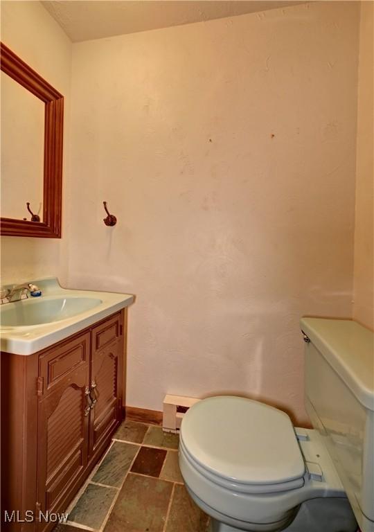 48846 Cain Ridge Rd, Clarington, OH 43915 - bathroom with vanity, stone finish flooring, and a baseboard heating unit