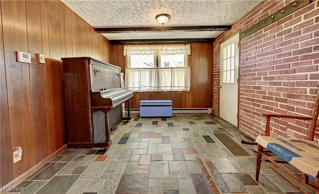 48846 Cain Ridge Rd, Clarington, OH 43915 - living area featuring wood walls, a baseboard radiator, stone tile flooring, plenty of natural light, and a textured ceiling