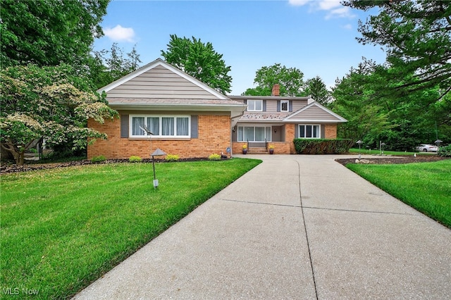 21349 Shelburne, Shaker Heights, OH 44122 - view of front facade with brick siding, a chimney, a front yard, and concrete driveway