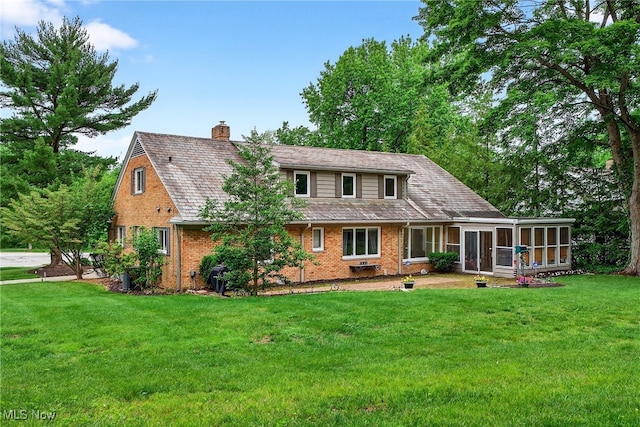 21349 Shelburne, Shaker Heights, OH 44122 - back of house with a sunroom, a chimney, brick siding, and a yard