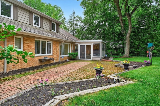 21349 Shelburne, Shaker Heights, OH 44122 - back of house with a sunroom, a patio, a lawn, and brick siding