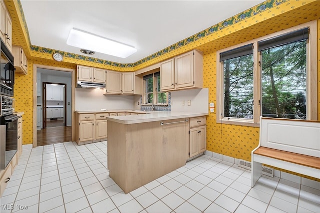 21349 Shelburne, Shaker Heights, OH 44122 - kitchen featuring wallpapered walls, light countertops, a peninsula, light tile patterned floors, and under cabinet range hood
