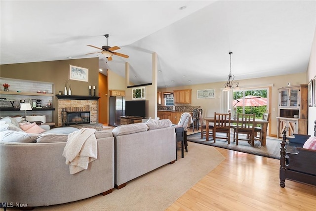 4568 Woodstone Ave NW, Massillon, OH 44647 - living area featuring a fireplace, wood finished floors, ceiling fan, and vaulted ceiling