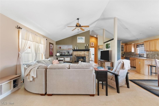 4568 Woodstone Ave NW, Massillon, OH 44647 - living room with a ceiling fan, a stone fireplace, vaulted ceiling, and light carpet
