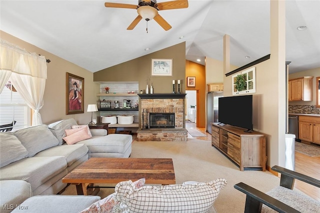 4568 Woodstone Ave NW, Massillon, OH 44647 - living room featuring ceiling fan, vaulted ceiling, a stone fireplace, and light colored carpet
