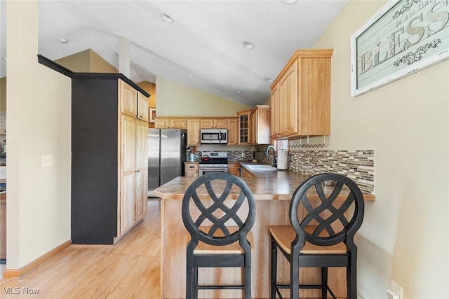 4568 Woodstone Ave NW, Massillon, OH 44647 - kitchen with appliances with stainless steel finishes, a peninsula, lofted ceiling, decorative backsplash, and glass insert cabinets