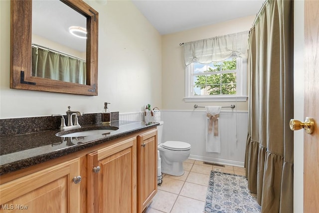 4568 Woodstone Ave NW, Massillon, OH 44647 - bathroom featuring vanity, tile patterned floors, and a wainscoted wall