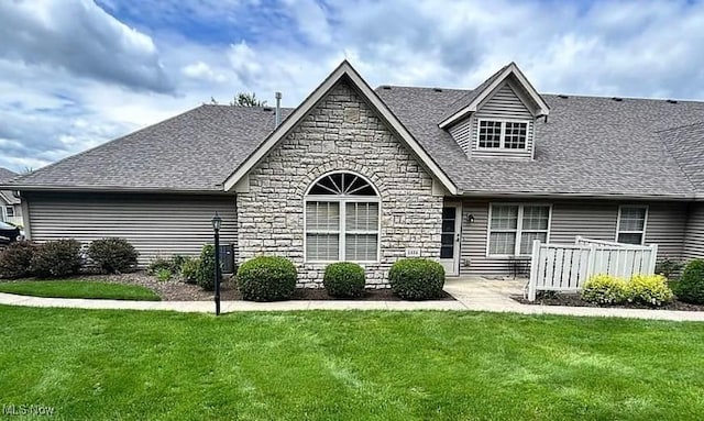 1534 Tylers Mill Ln NE, Massillon, OH 44646 - view of front facade featuring stone siding, a front yard, and a shingled roof