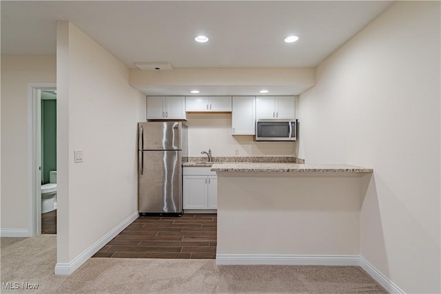 3925 Waterford Ct, Orange, OH 44122 - kitchen featuring appliances with stainless steel finishes, white cabinetry, recessed lighting, light stone counters, and dark carpet