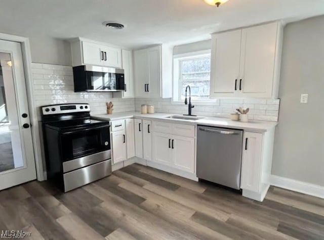 2511 Sherr Ave SE, Canton, OH 44707 - kitchen featuring stainless steel appliances, white cabinets, light countertops, tasteful backsplash, and dark wood-type flooring