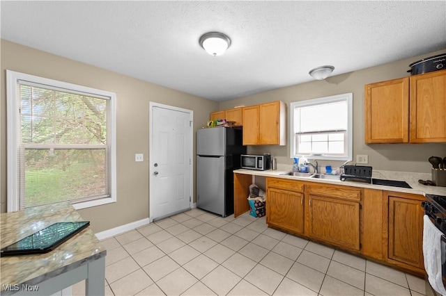 630 E 103rd St, Cleveland, OH 44108 - kitchen featuring appliances with stainless steel finishes, light countertops, light tile patterned floors, and a textured ceiling