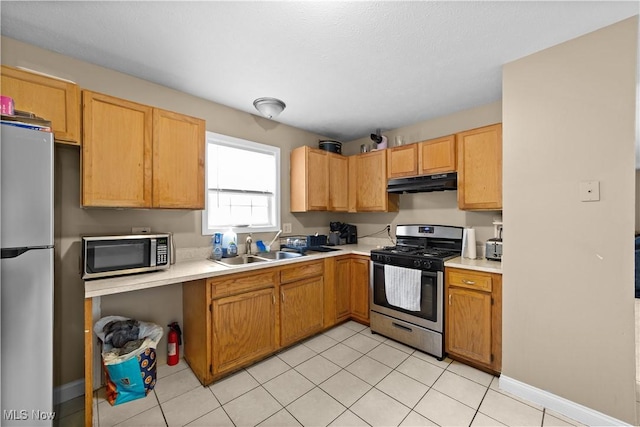 630 E 103rd St, Cleveland, OH 44108 - kitchen featuring stainless steel appliances, under cabinet range hood, light countertops, and light tile patterned flooring