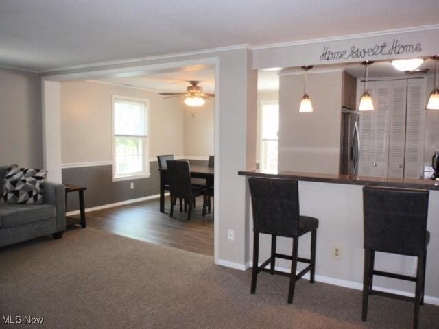 23 Valley Forge Ln, Elyria, OH 44035 - kitchen with stainless steel refrigerator, carpet, a kitchen breakfast bar, ornamental molding, and a ceiling fan