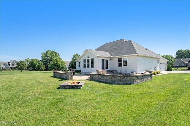 6782 Fawndale Dr, Medina, OH 44256 - rear view of house with a fire pit, a lawn, a garage, and driveway