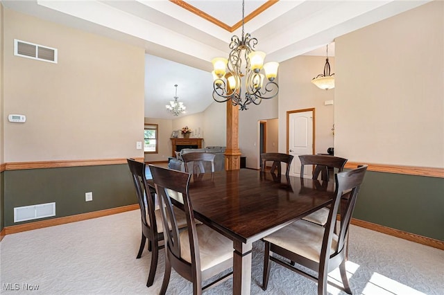 6782 Fawndale Dr, Medina, OH 44256 - dining space with light colored carpet, a chandelier, high vaulted ceiling, a tray ceiling, and a fireplace