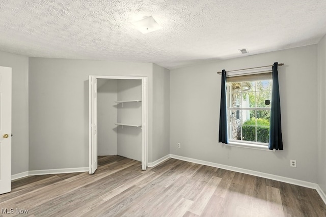 232 Damon Dr, Munroe Falls, OH 44262 - unfurnished bedroom with wood finished floors, a closet, and a textured ceiling