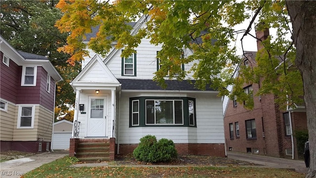 13558 Cedar Rd, University Heights, OH 44118 - view of front of house featuring entry steps, a shingled roof, a garage, and an outdoor structure