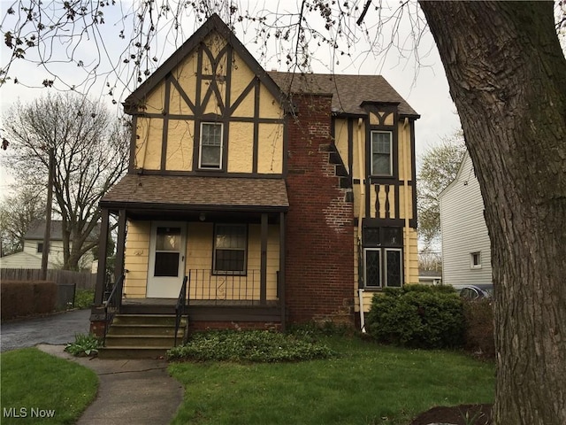 265 E 191st St, Euclid, OH 44119 - tudor home featuring covered porch, roof with shingles, and stucco siding