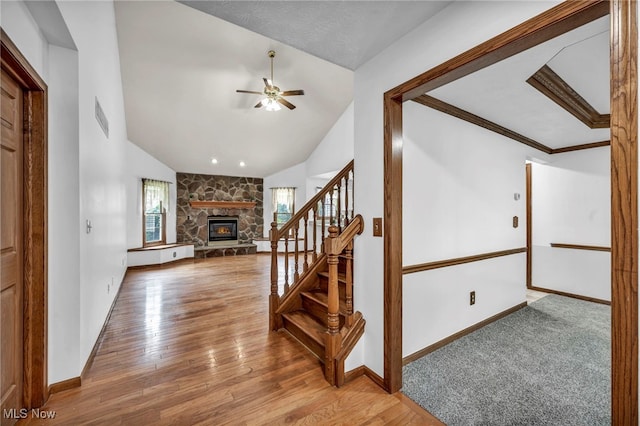 3578 County Line Rd, Madison, OH 44057 - stairs featuring lofted ceiling, ceiling fan, a stone fireplace, and wood finished floors