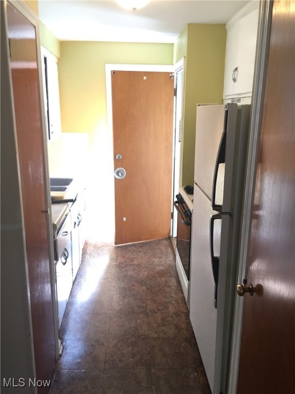 19030 Lake Shore Blvd, Euclid, OH 44119 - kitchen featuring range, white cabinetry, and freestanding refrigerator