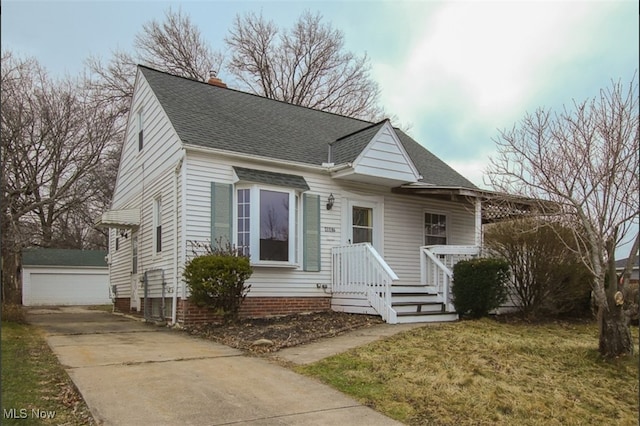 4607 Lincoln Ave, Parma, OH 44134 - view of front of home with an outbuilding, roof with shingles, a chimney, covered porch, and a detached garage