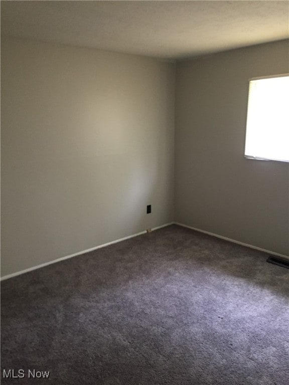 6078 Randolph Rd, Bedford Heights, OH 44146 - spare room with dark colored carpet and baseboards