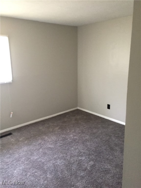 6078 Randolph Rd, Bedford Heights, OH 44146 - spare room featuring dark carpet and baseboards