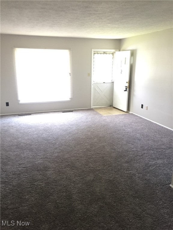 6078 Randolph Rd, Bedford Heights, OH 44146 - carpeted empty room featuring a textured ceiling and baseboards