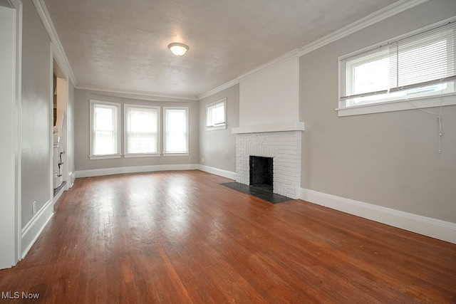 3509 Silsby Rd, University Heights, OH 44118 - unfurnished living room featuring ornamental molding, wood finished floors, and a brick fireplace