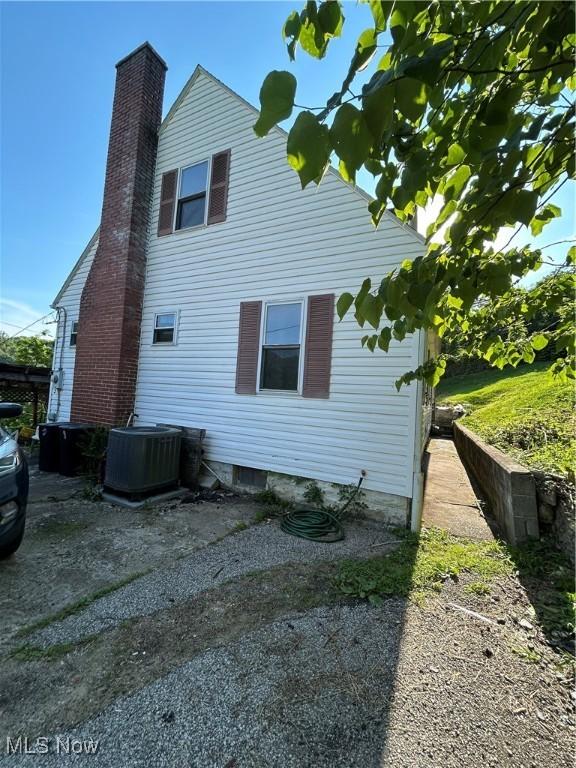 73 High St, Clay, WV 25043 - view of side of home with a chimney and a central air condition unit