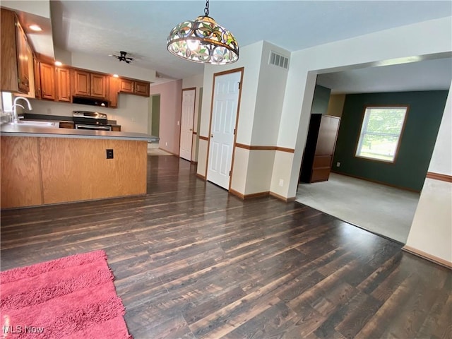 13781 Rustic Dr, North Royalton, OH 44133 - kitchen featuring stainless steel electric range oven, brown cabinets, a peninsula, dark wood-style flooring, and open floor plan