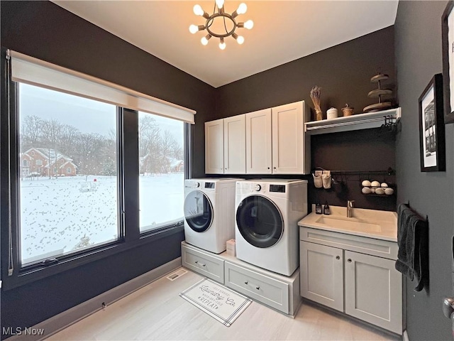 7634 Worlington Dr, Solon, OH 44139 - laundry room with cabinet space, washer and clothes dryer, and a chandelier