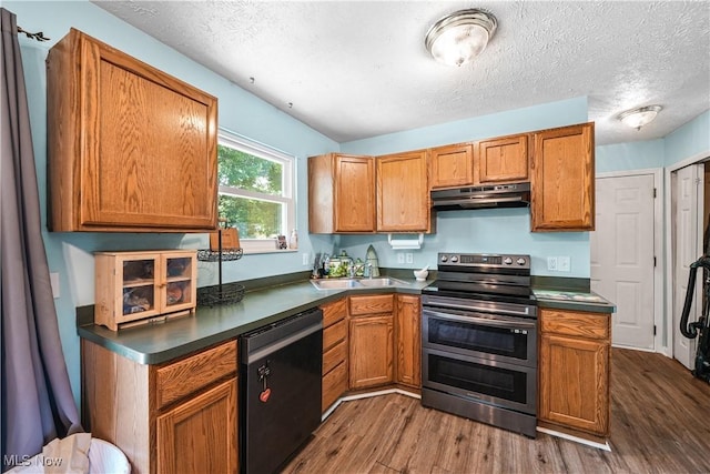 9009 Oak Ct, Windham, OH 44288 - kitchen featuring dishwashing machine, double oven range, under cabinet range hood, dark wood finished floors, and dark countertops
