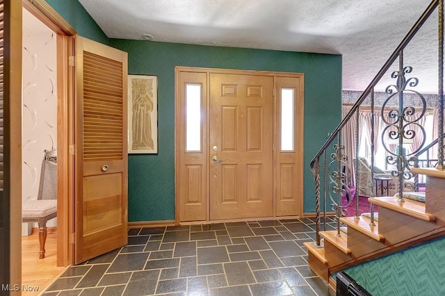 9502 Winchester Vly, Chesterland, OH 44026 - entrance foyer with a textured ceiling, dark stone finish flooring, and stairway