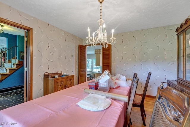 9502 Winchester Vly, Chesterland, OH 44026 - dining space with a chandelier, stairway, wallpapered walls, a textured ceiling, and wood finished floors