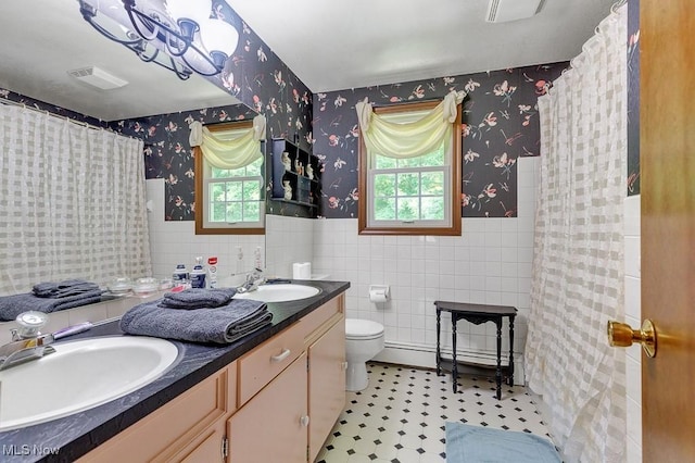 9502 Winchester Vly, Chesterland, OH 44026 - full bathroom with wallpapered walls, a baseboard radiator, tile walls, wainscoting, and double vanity