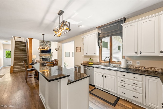 3519 Hawthorne Trl, Broadview Heights, OH 44147 - kitchen featuring dishwasher, a stone fireplace, white cabinets, hardwood / wood-style flooring, and a kitchen island