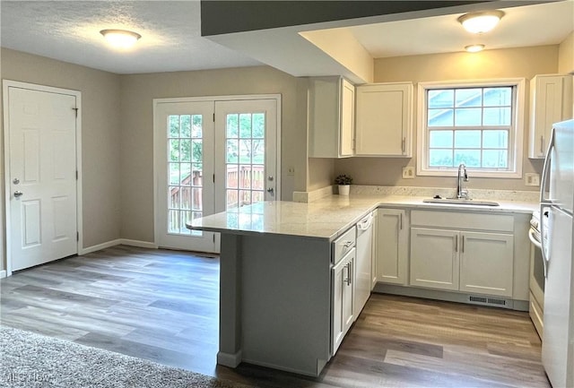 8602 Wedgewood Ave NW, North Canton, OH 44720 - kitchen featuring a peninsula, healthy amount of natural light, white appliances, and white cabinetry