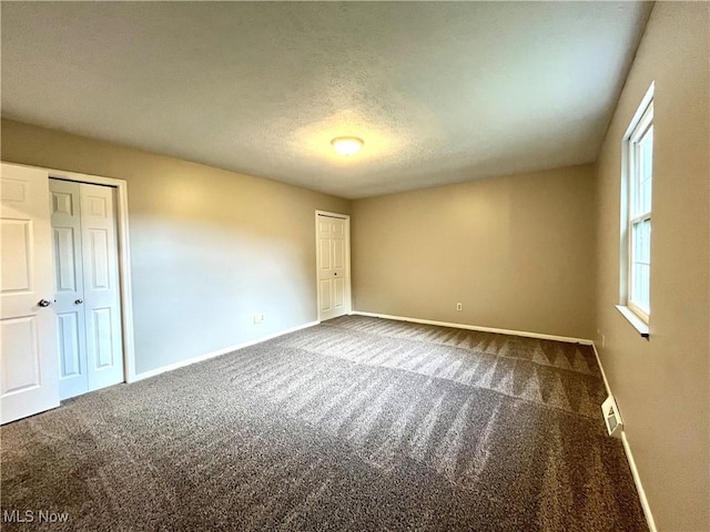 8602 Wedgewood Ave NW, North Canton, OH 44720 - unfurnished bedroom featuring carpet floors, multiple closets, and a textured ceiling