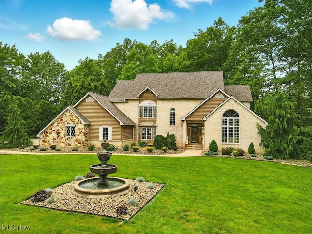 2526 Ashbrook Dr, Ashtabula, OH 44004 - traditional-style home featuring stone siding, a front lawn, and a shingled roof
