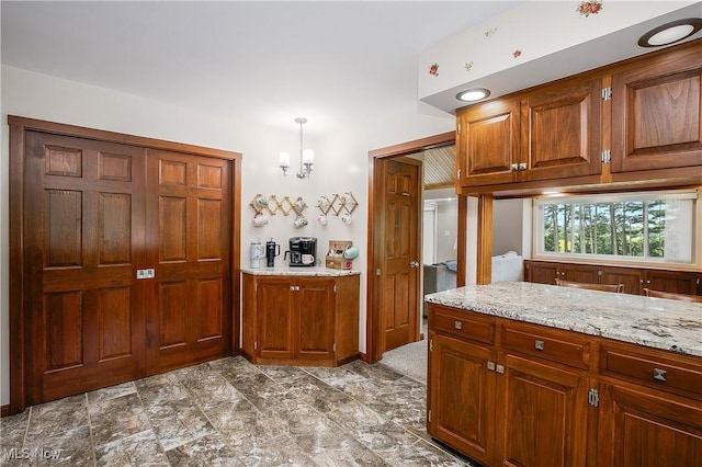 13645 Salem Church St NE, Paris, OH 44669 - kitchen with light stone counters, a chandelier, and brown cabinetry