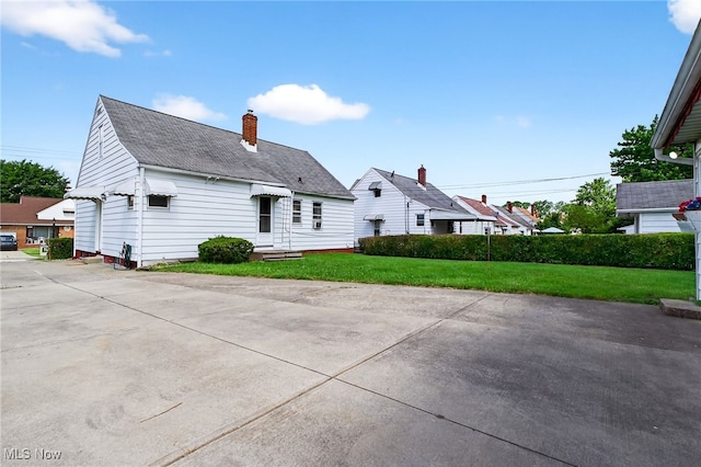 5077 Catherine St, Maple Heights, OH 44137 - rear view of house with a yard, a chimney, and roof with shingles
