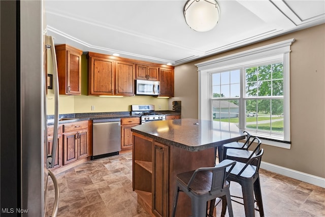 5215 River Rd, Madison, OH 44057 - kitchen with appliances with stainless steel finishes, a kitchen breakfast bar, dark countertops, and stone finish floors