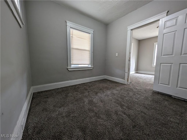 1268 E 169th St, Cleveland, OH 44110 - unfurnished room with dark carpet and baseboards