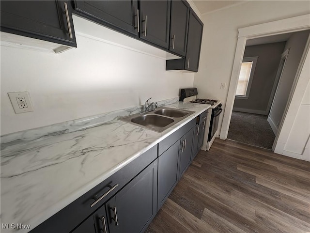 1268 E 169th St, Cleveland, OH 44110 - kitchen with gas stove, dark wood finished floors, and dark cabinetry