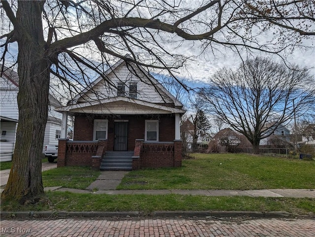 1268 E 169th St, Cleveland, OH 44110 - view of front of house featuring a porch, a front lawn, and brick siding