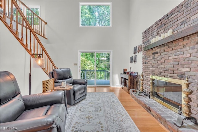 820 Old Spring Rd, Copley, OH 44321 - living room featuring stairs, a high ceiling, wood finished floors, and a brick fireplace