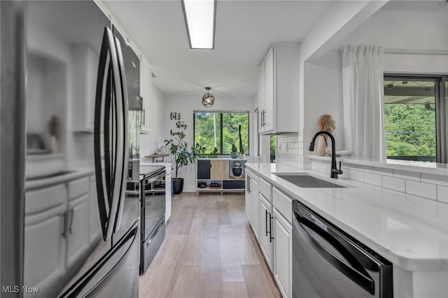 3800 Rosemont Blvd Unit 114C, Akron, OH 44333 - kitchen featuring smart refrigerator, dishwasher, black range with electric stovetop, light wood-style floors, and decorative backsplash