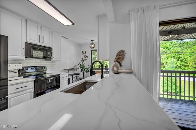 3800 Rosemont Blvd Unit 114C, Akron, OH 44333 - kitchen featuring black appliances, tasteful backsplash, white cabinets, and light stone counters